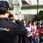 Un policía del Servicio de Atención al Turista Extranjero hace una fotografía a unos turistas