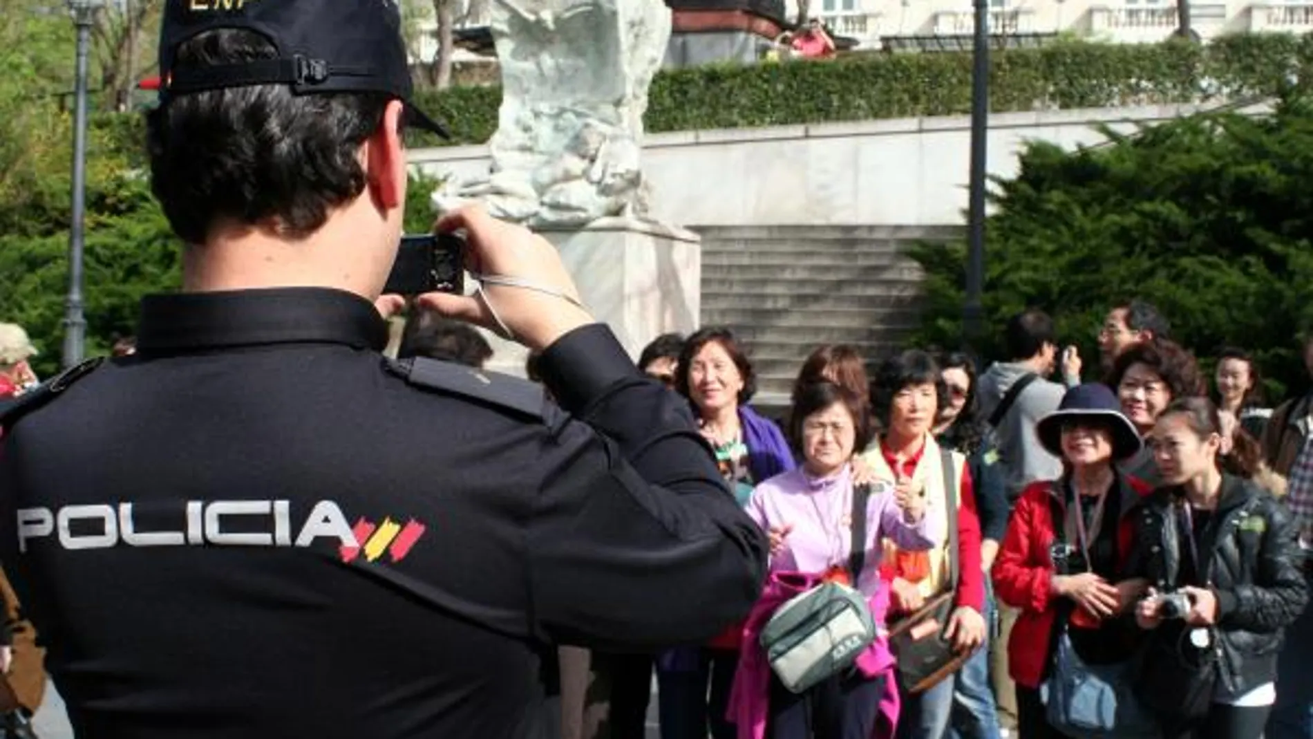 Un policía del Servicio de Atención al Turista Extranjero hace una fotografía a unos turistas