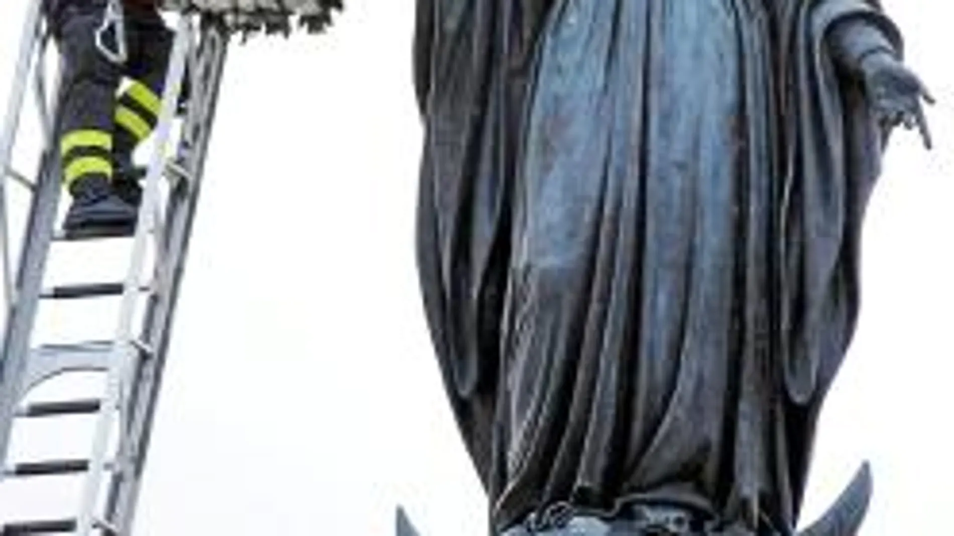 Un bombero honra a la imagen de la Inmaculada en la Plaza de España de Roma