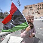 Una mujer ondea una bandera en la plaza de los Mártires de Trípoli