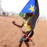 Una joven sursudanesa, con la bandera del nuevo país, celebra en Juba la victoria de la opción independentista en el referéndum