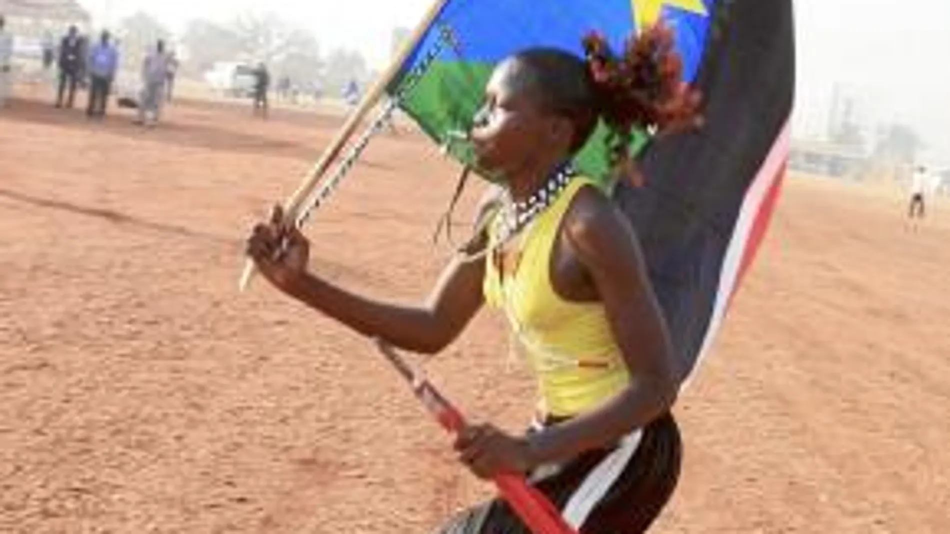 Una joven sursudanesa, con la bandera del nuevo país, celebra en Juba la victoria de la opción independentista en el referéndum