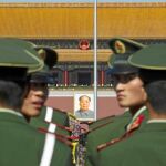 Policías chinos hacen guardia en la Plaza de Tiananmen frente a un retrato de Mao Tse Tung