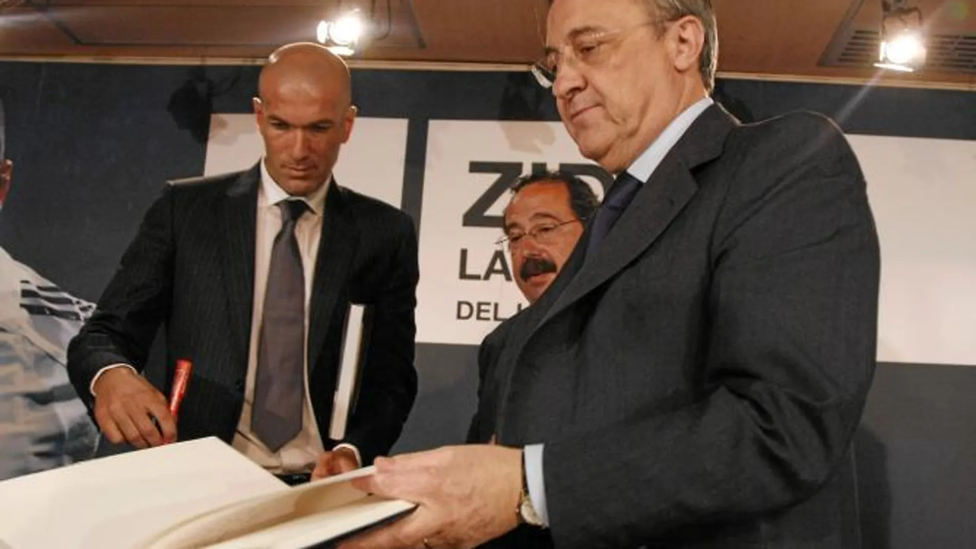 Zidane y Florentino Pérez, con Ortego en el medio, firman un ejemplar del libro