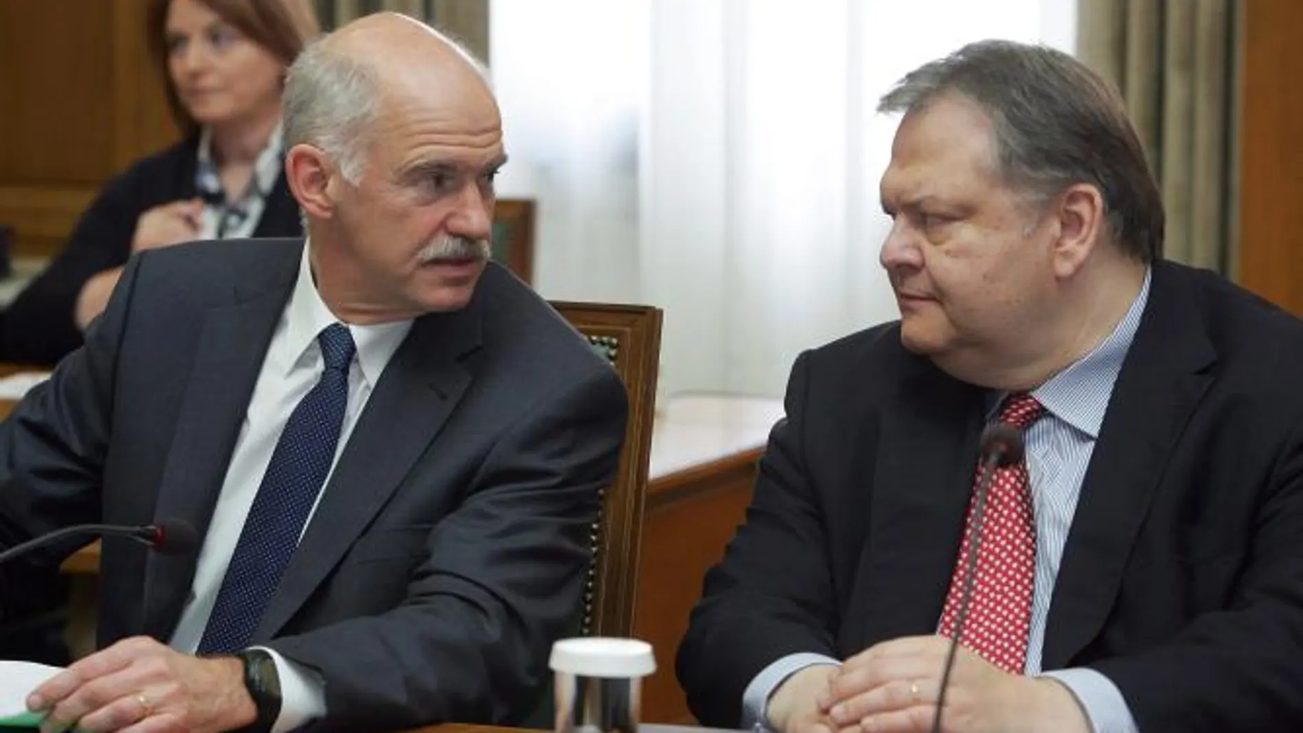 El primer ministro griego, Yorgos Papandréu (i), habla con el recién nombrado ministro de Finanzas de Grecia, Evangelos Venizelos
