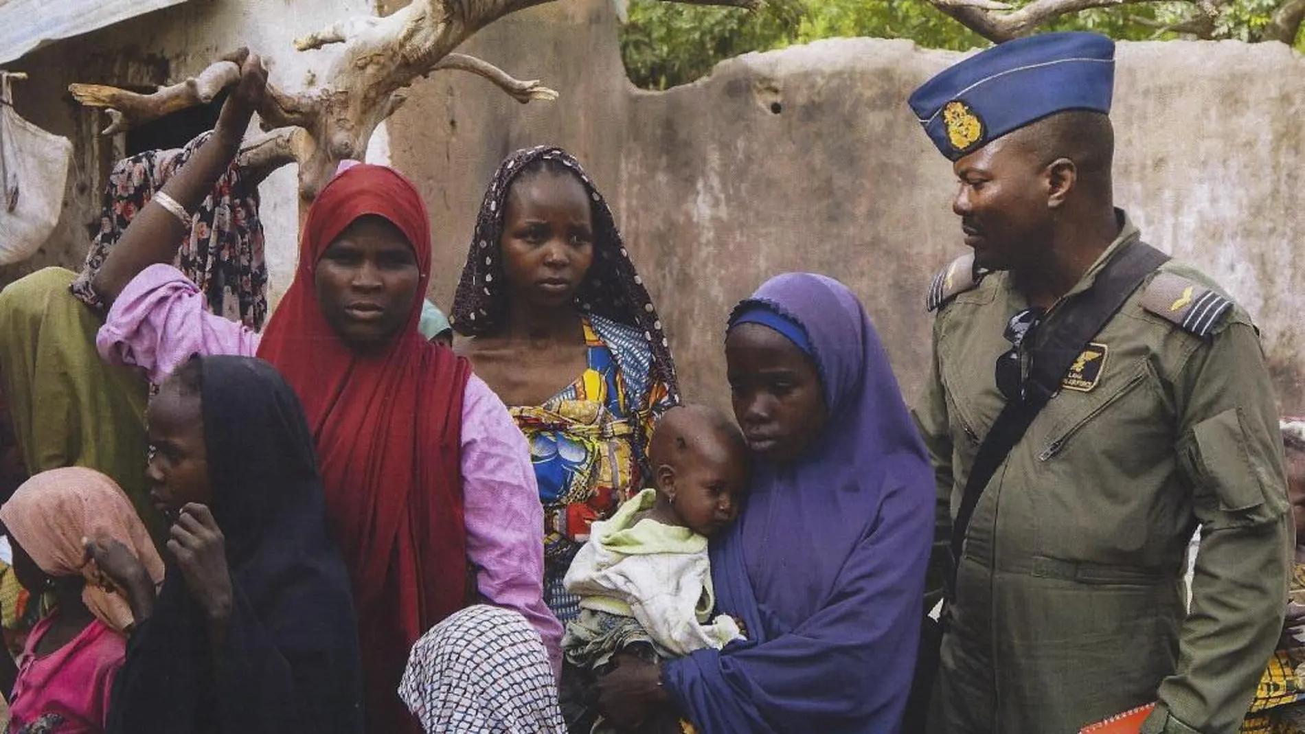 Fotografía facilitada por el Ejército de Nigeria que muestra a un soldado rodeado de un grupo de mujeres y niños rescatados por el Ejército durante una operación contra el grupo yihadista Boko Haram.