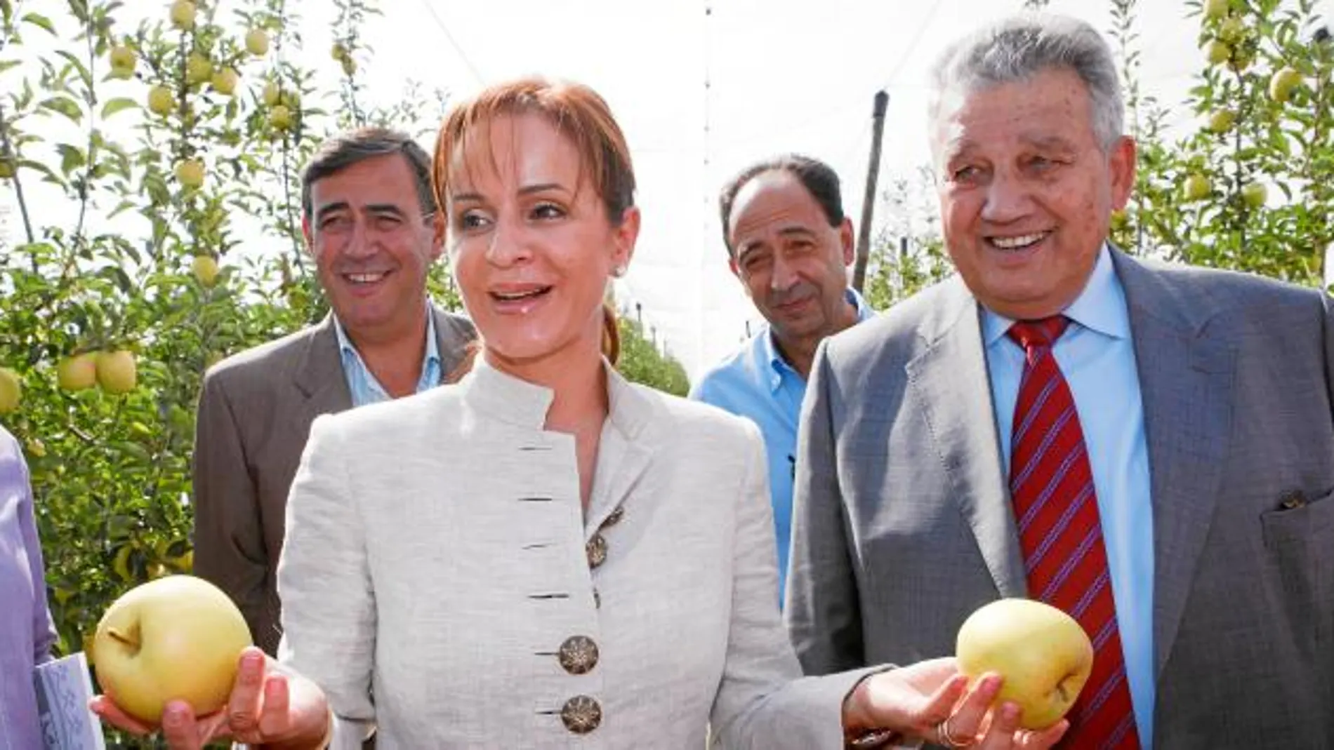 La consejera Silvia Clemente muestra dos manzanas de Nufri, en presencia de Antonio Pardo y Francisco Argiles