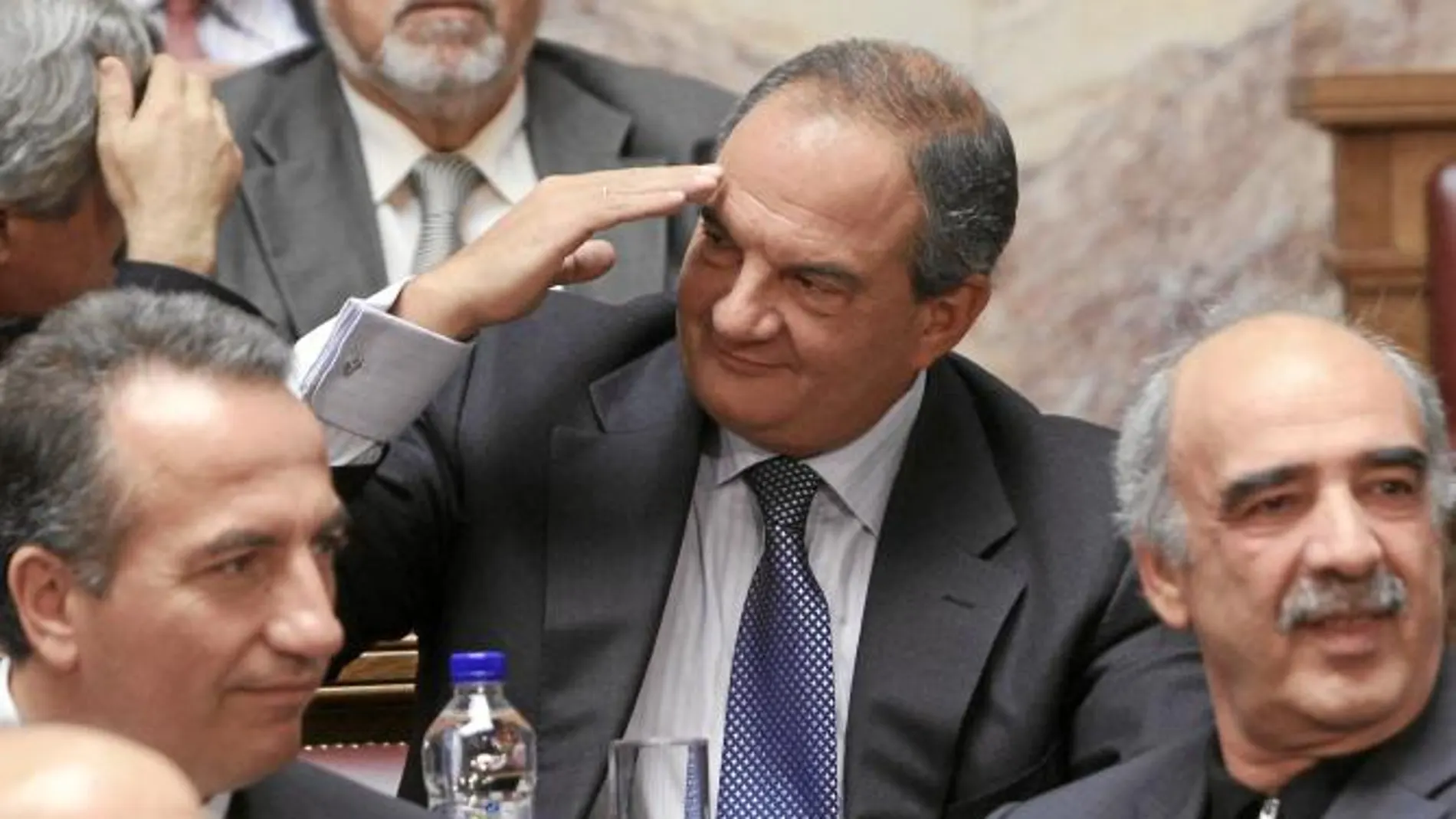 Costas Karamanlis, el ex primer ministro conservador, conversa con miembros de su partido, ayer, en el Parlamento griego