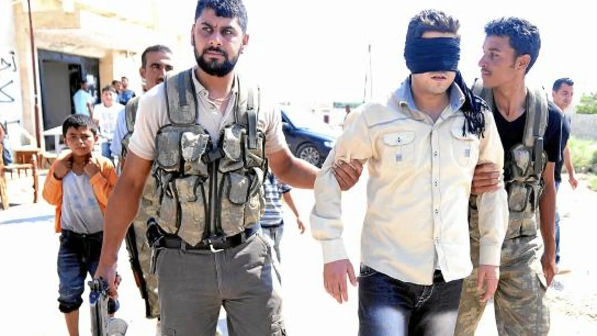 Un grupo de rebeldes sirios detiene a un hombre acusado de traidor cerca de Alepo