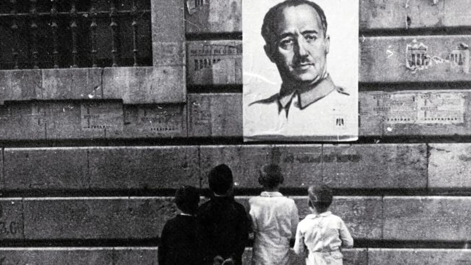 Dos niños miran un retrato de Franco