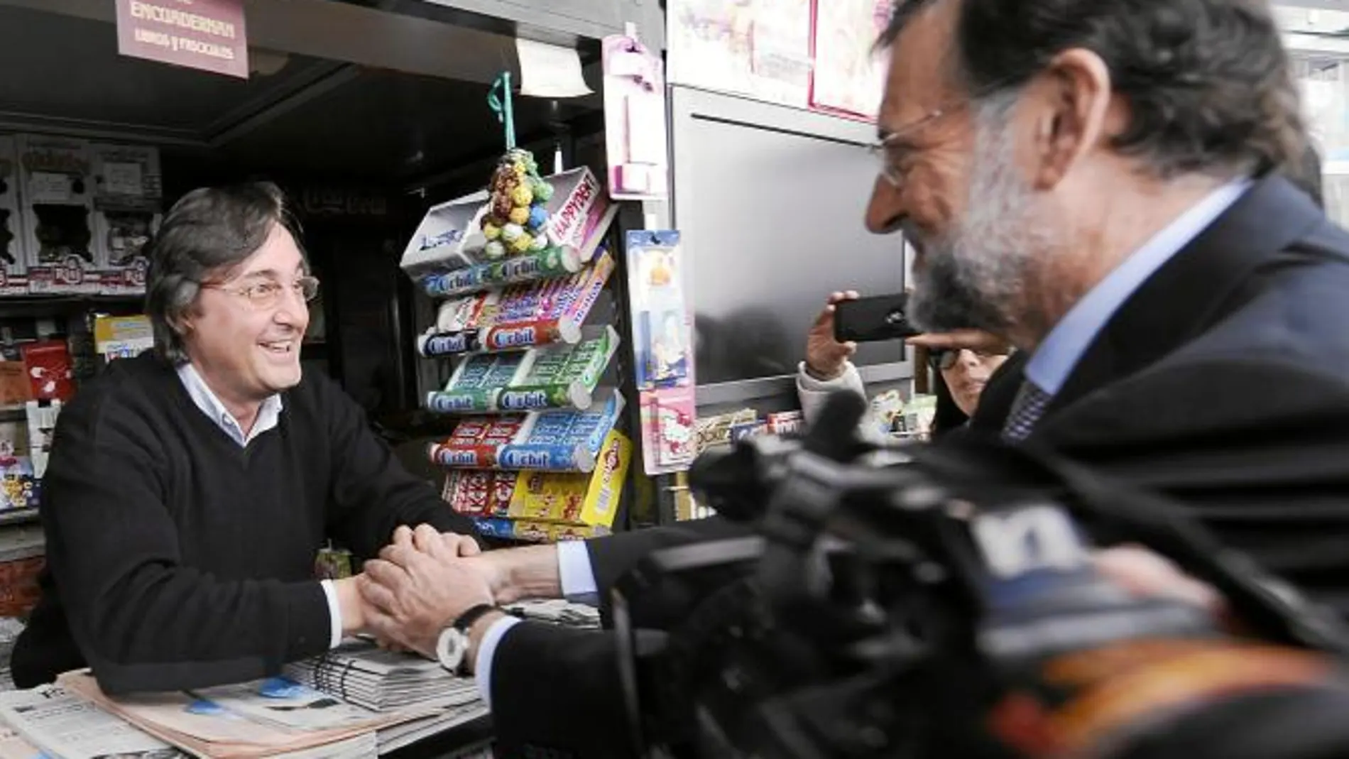 Mariano rajoy conversa con un quiosquero ayer en Santander