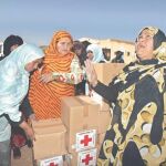 Mujeres saharauis reciben la ayuda de Cruz Roja en el campamento de refugiados de Tinduf (Argelia)