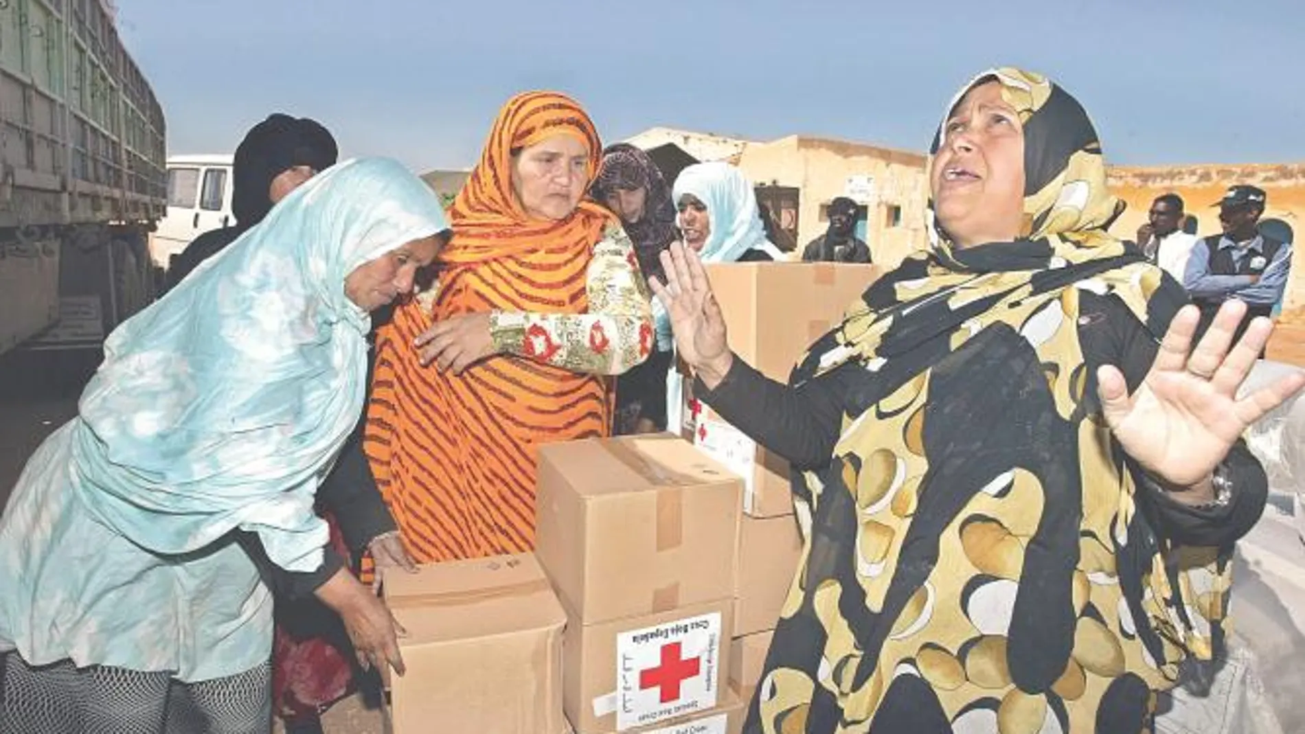 Mujeres saharauis reciben la ayuda de Cruz Roja en el campamento de refugiados de Tinduf (Argelia)