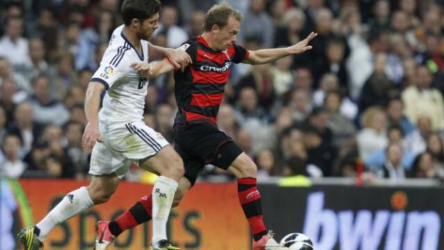 Michael Krohn-Dehli (d) intenta marcharse del centrocampista del Real Madrid Xabi Alonso (i),