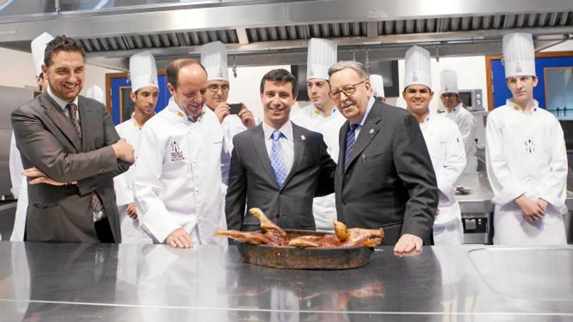 Alberto y Cándido López cortan un cochinillo en la apertura del II Curso Superior de Ayudante de Cocina