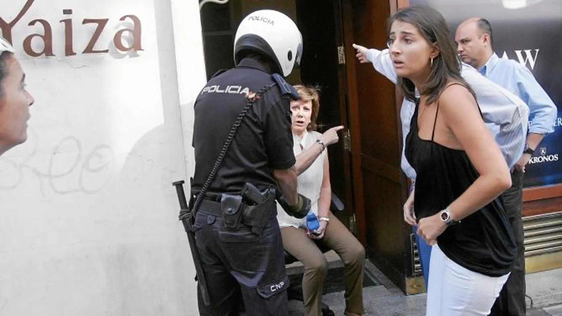Arriba, una empleada en plena crisis de ansiedad; abajo, uno de los atracadores ya esposado