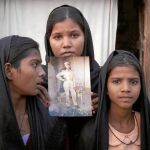 Las tres hijas de Asia Bibi posan con una foto de su madre