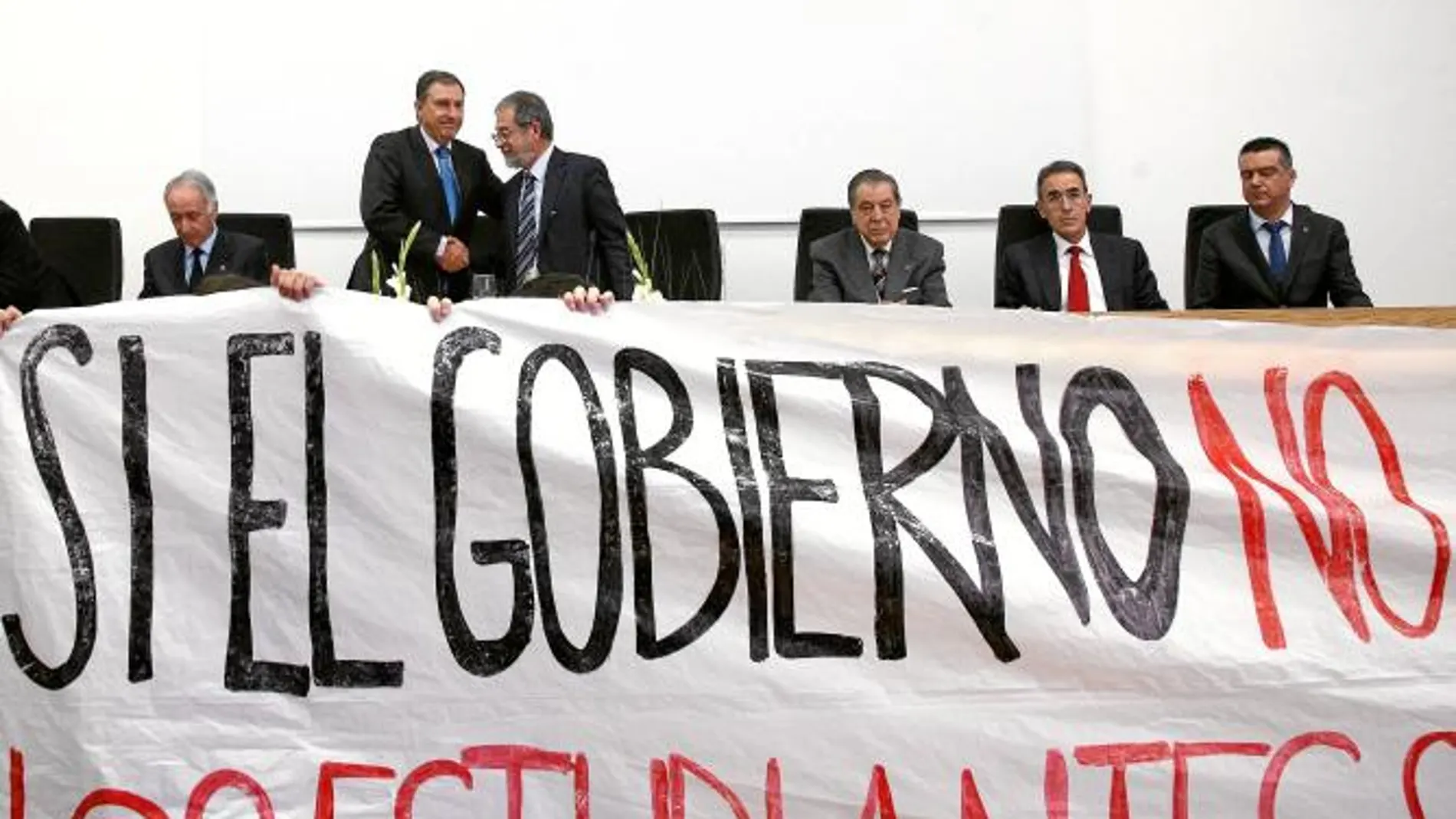 Momento en el que el rector Marcos Sacristán, en la imagen dando la mano al consejero Juan José Mateos, decide suspender el acto