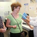 Una enfermera vacuna a una mujer durante la campaña de prevención contra la gripe