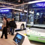 Varios visitantes contemplan los autobuses que se exponen en una feria del sector