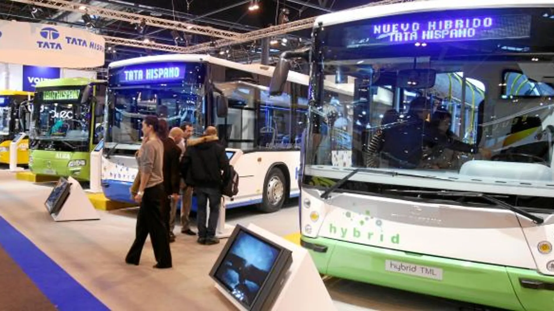 Varios visitantes contemplan los autobuses que se exponen en una feria del sector