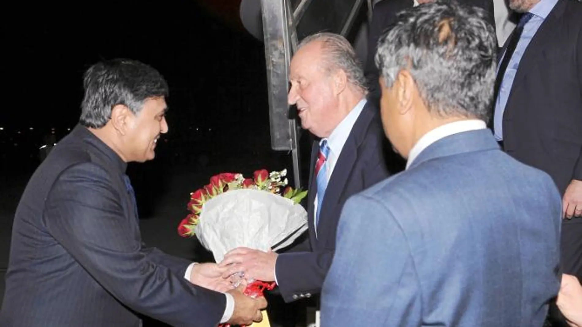 El Rey, tras aterrizar en el aeropuerto de Bombay, ayer, es recibido por el embajador de India en España, Sunil Lal, que le entrega un ramo de flores. Acompañan a Don Juan Carlos durante este viaje los ministros de Exteriores, Industria, Defensa y Foment