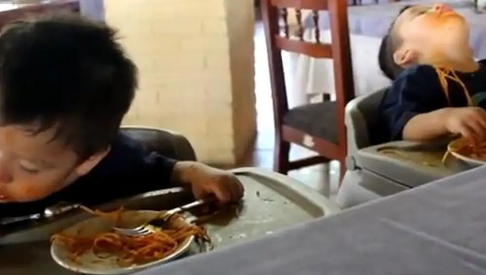Niños se duermen mientras comen un plato de espaguetis