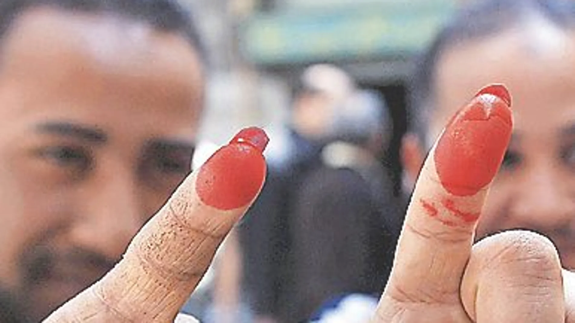 Dos electores egipcios muestras con satisfacción la prueba del voto