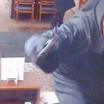 Una atracador con máscara amenaza con una pistola en un banco