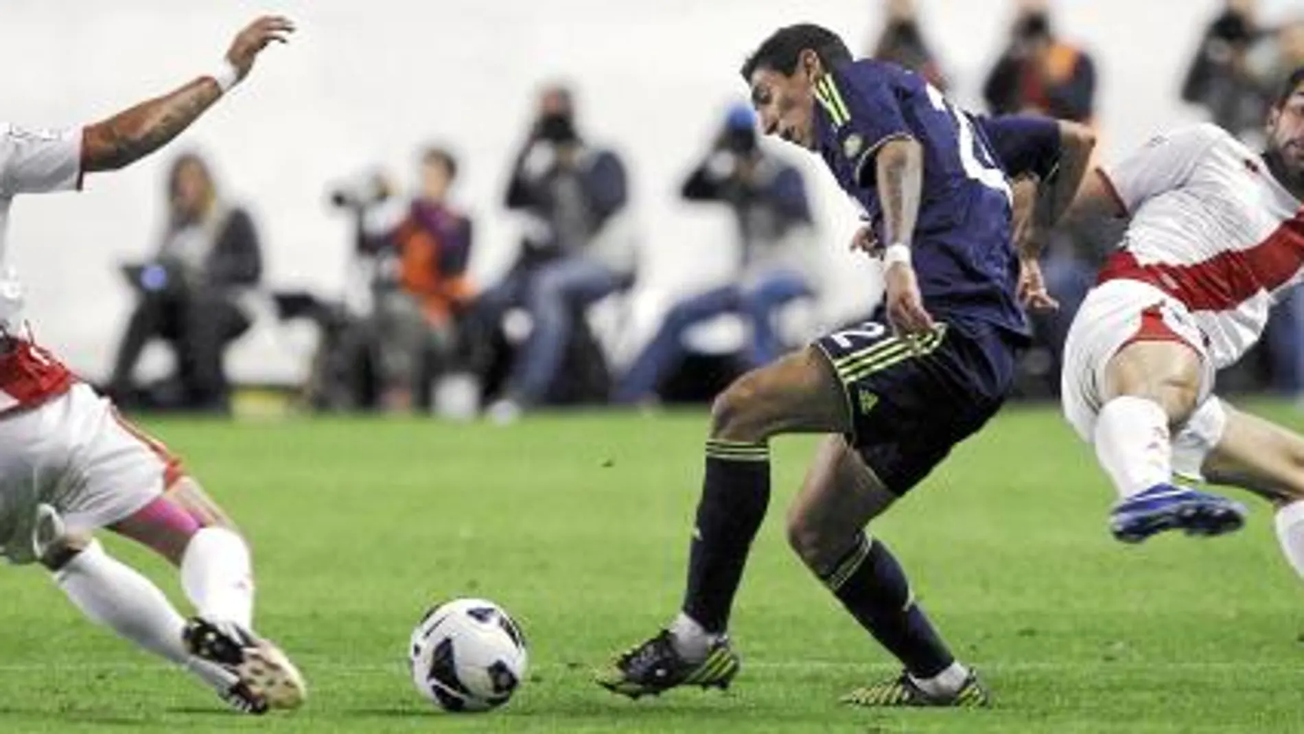 Di María intenta deshacerse de la presión de dos jugadores rayistas. El argentino sirvió el primer gol en bandeja a Benzema