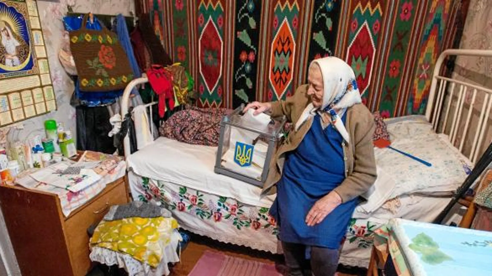 Una anciana ucraniana vota en su casa gracias a una urna portátil