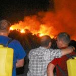 Varios vecinos de la localidad berciana de Villar de los Barrios, cercana a Ponferrada, observan, impotentes, el avance de las llamas cerca de sus casas en el incendio que se produjo el pasado 23 de julio