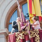 El presidente de la Generalitat, Alberto Fabra, besa la Real Senyera en el balcón del Ayuntamiento, ante la atenta mirada de Rita Barberá