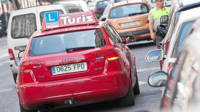 Un coche de autoescuela recorre las calles de Valencia durante la ejecución de las prácticas