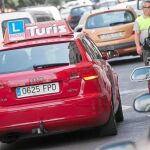 Un coche de autoescuela recorre las calles de Valencia durante la ejecución de las prácticas