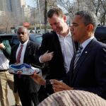 Obama firma en un zapatilla a un seguidor en Chicago