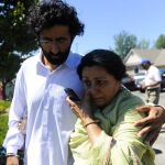Un hombre y una mujer caminan juntos mientras aguardan noticias tras el tiroteo que se ha producido en un templo de la comunidad sij en Oak Creek