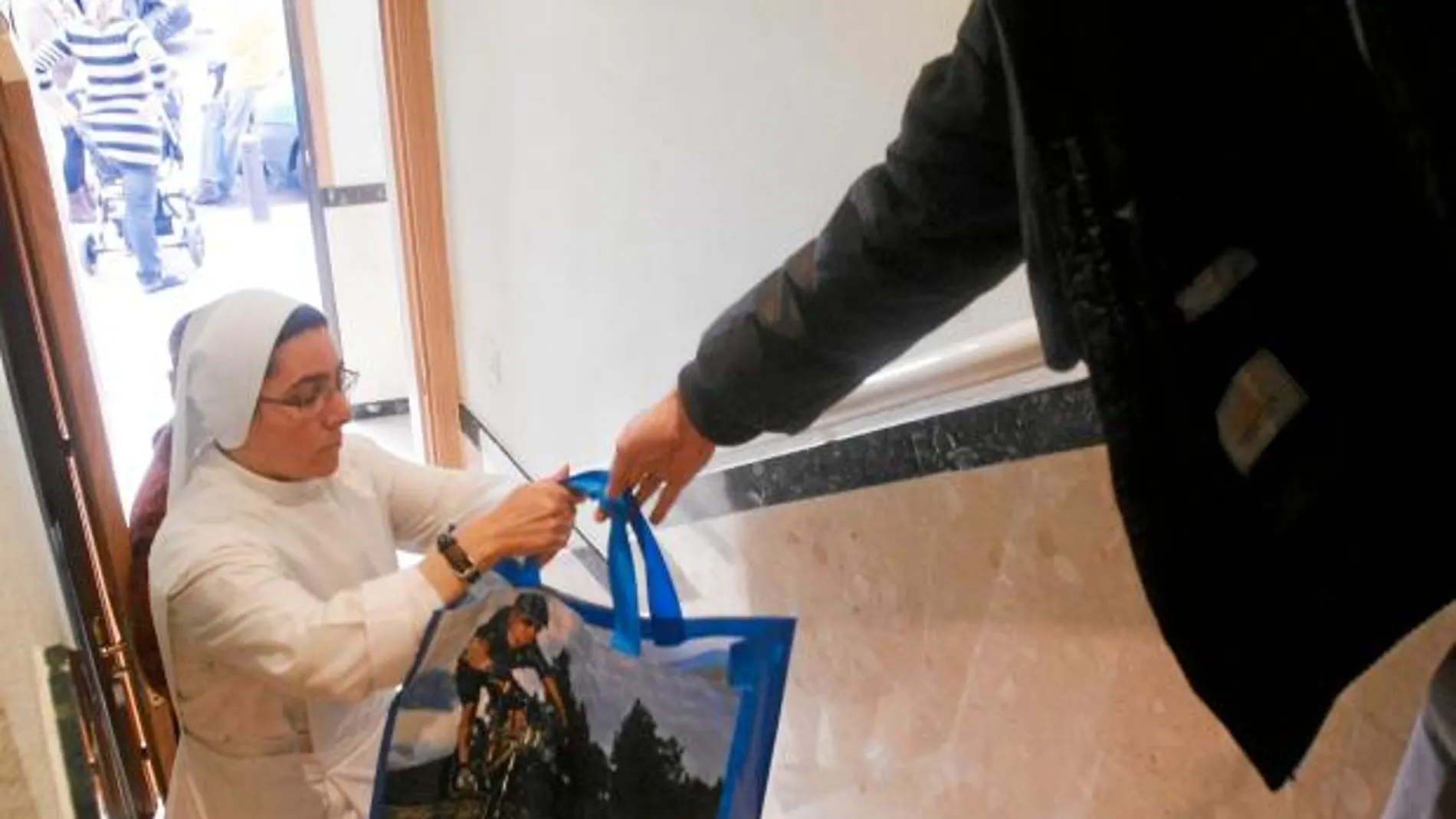 En la imagen, una monja valenciana desempeña sus tareas de ayuda a domicilio