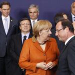 La canciller alemana Angela Merkel (i) conversa con el presidente francés François Hollande (d) durante la foto de familia de la cumbre de jefes de Estado y de Gobierno de la Unión Europea