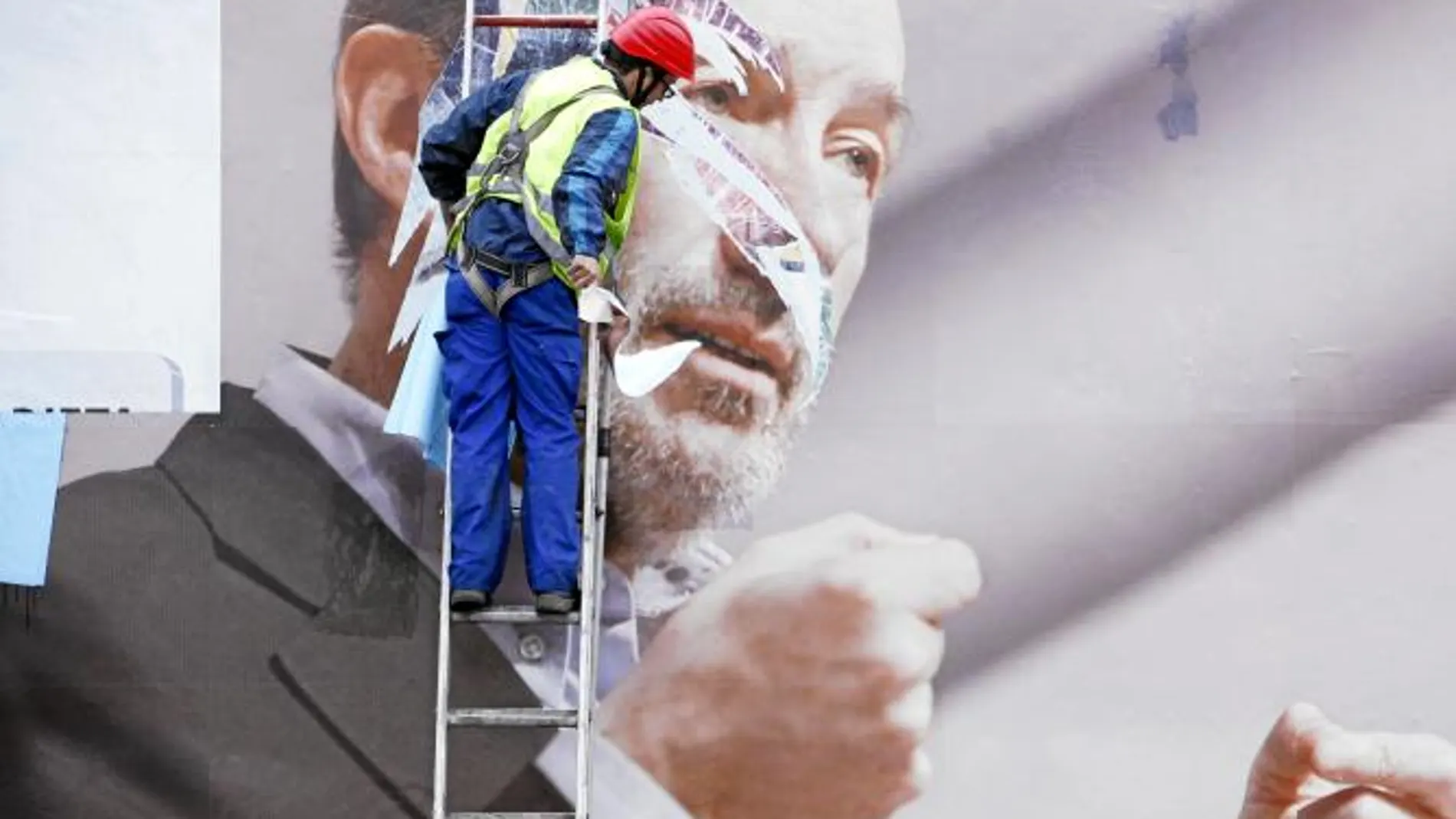 Un operario trabaja ayer en la retirada de un cartel electoral del aspirante socialista, Alfredo Pérez Rubalcaba