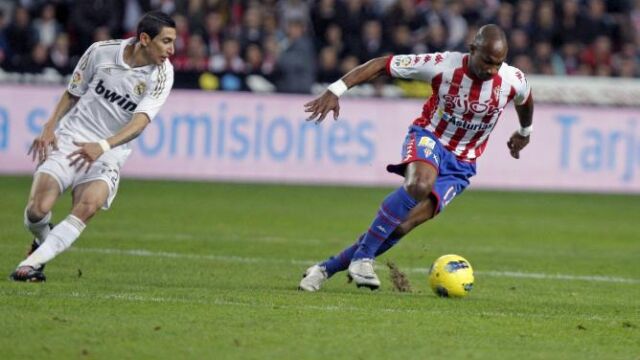 El defensa francés del Sporting de Gijón, Gregory Arnolin (d), controla la pelota ante la presión del delantero argentino del Real Madrid, Ángel di María