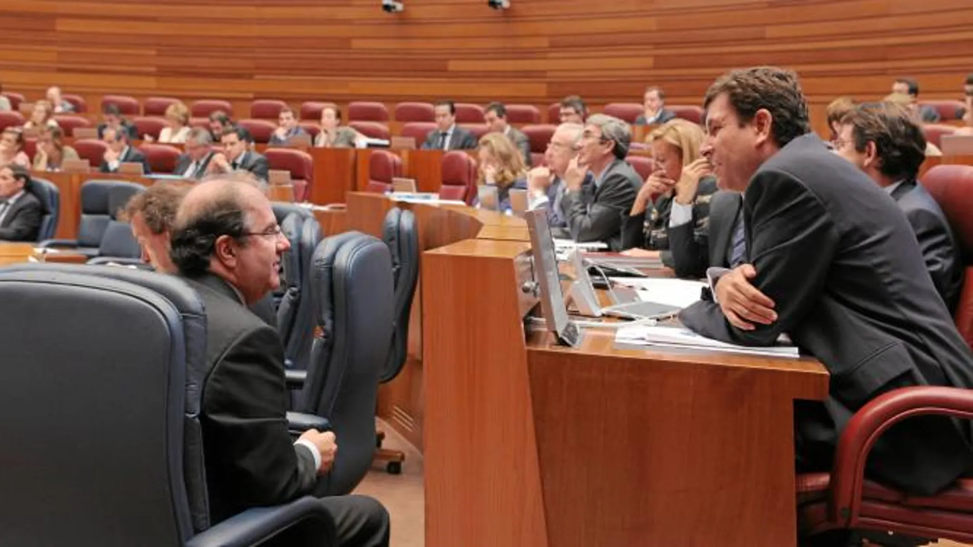 El presidente Herrera conversa con el portavoz popular, Carlos Fernández carriedo, ayer en las Cortes