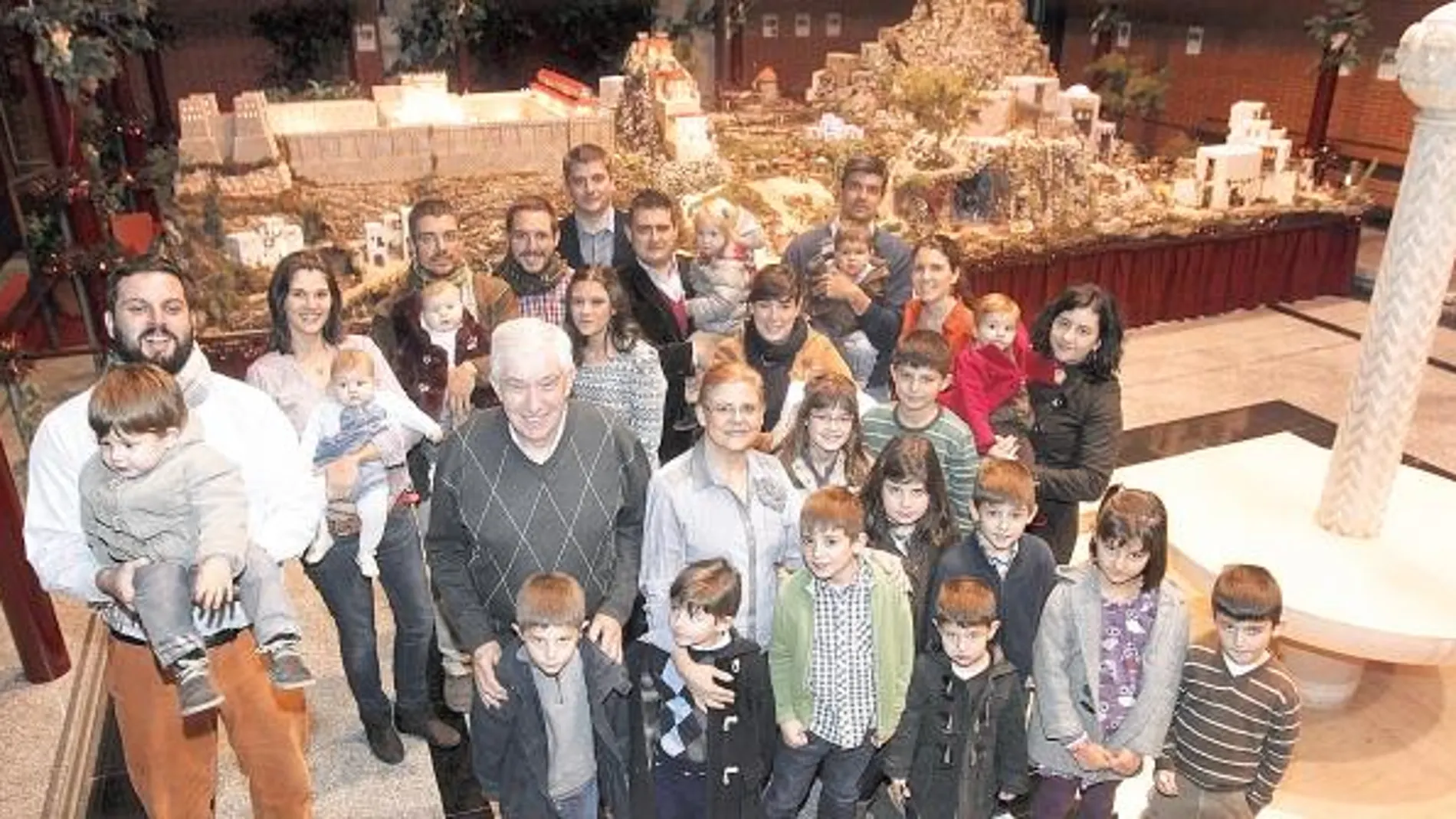 Ángel Medrano y su familia junto al belén de la parroquia Santa Catalina Labouré, en Madrid