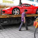 Un Ferrari 458 Spider es montado en la grúa tras ser comprado por un hombre joven en Shenzhen. Uno de cada cuatro productos de lujo en el mundo, termina en China