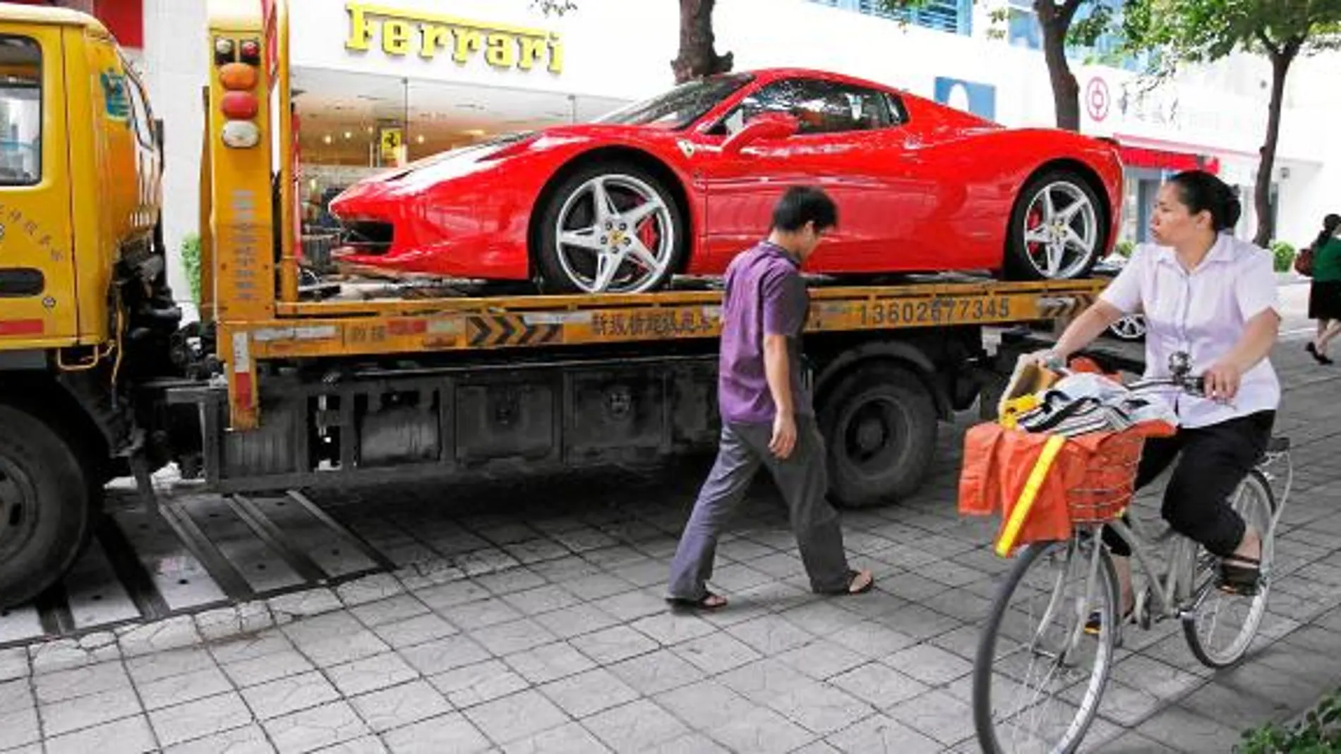 Un Ferrari 458 Spider es montado en la grúa tras ser comprado por un hombre joven en Shenzhen. Uno de cada cuatro productos de lujo en el mundo, termina en China