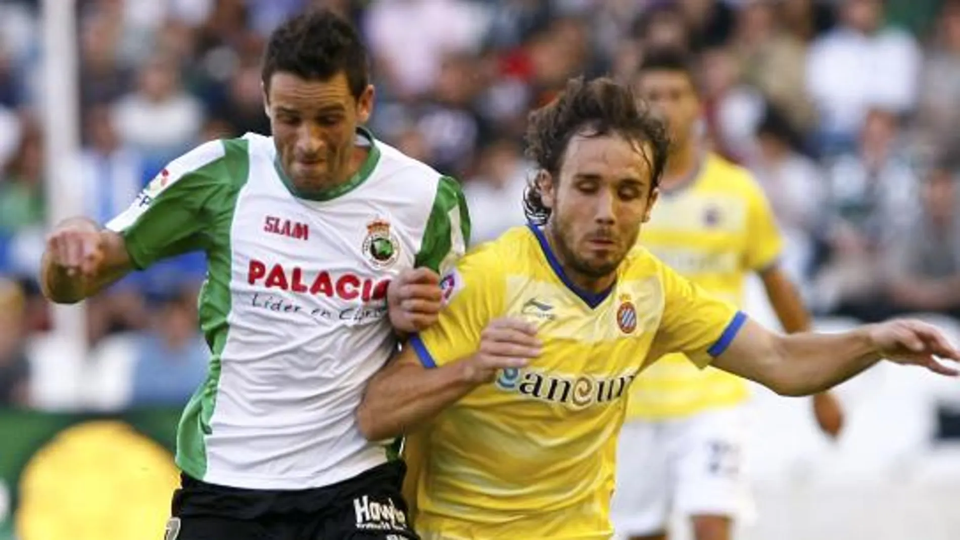 El centrocampista del Racing de Santander Manuel Arana (i) y el centrocampista del Espanyol Joan Verdú luchan por el balón