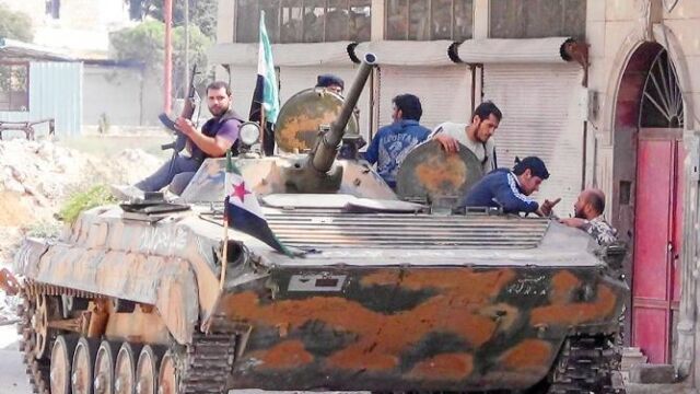 Miembros del Ejército Libre de Siria, ayer, con un tanque capturado en la provincia de Idlib