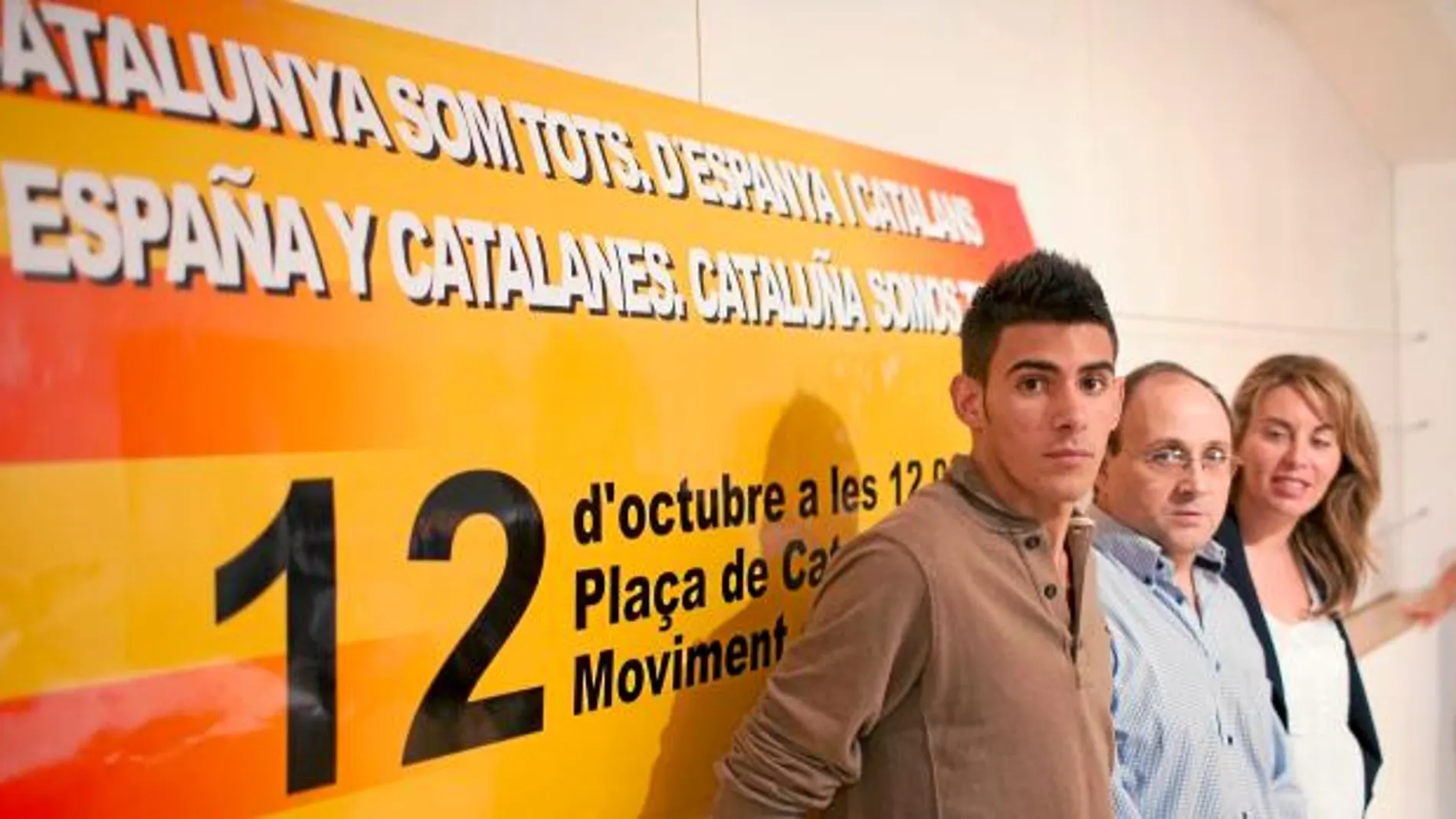 Xavi Reyes, Manel Parra y Annie Martínez posan ante la pancarta que estará en plaza Cataluña
