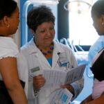 Una médica atiende a dos inmigrantes