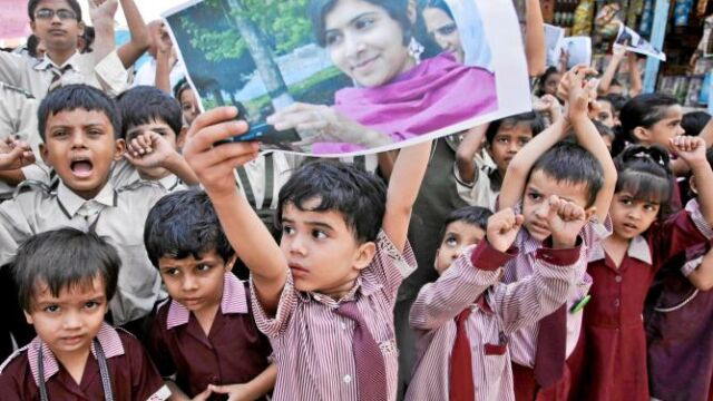 Un niño paquistaní levanta una imagen de Malala en una concentración a favor de ella, ayer en Karachi